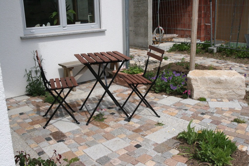 Kleiner Sitzplatz mit gemischtem Pflaster, dass f&uuml;r kleine betretbare Polsterstauden wie  Thymian, Sternmoos oder r&ouml;mische Kamille unterbrochen wurde. (M&uuml;nchen)